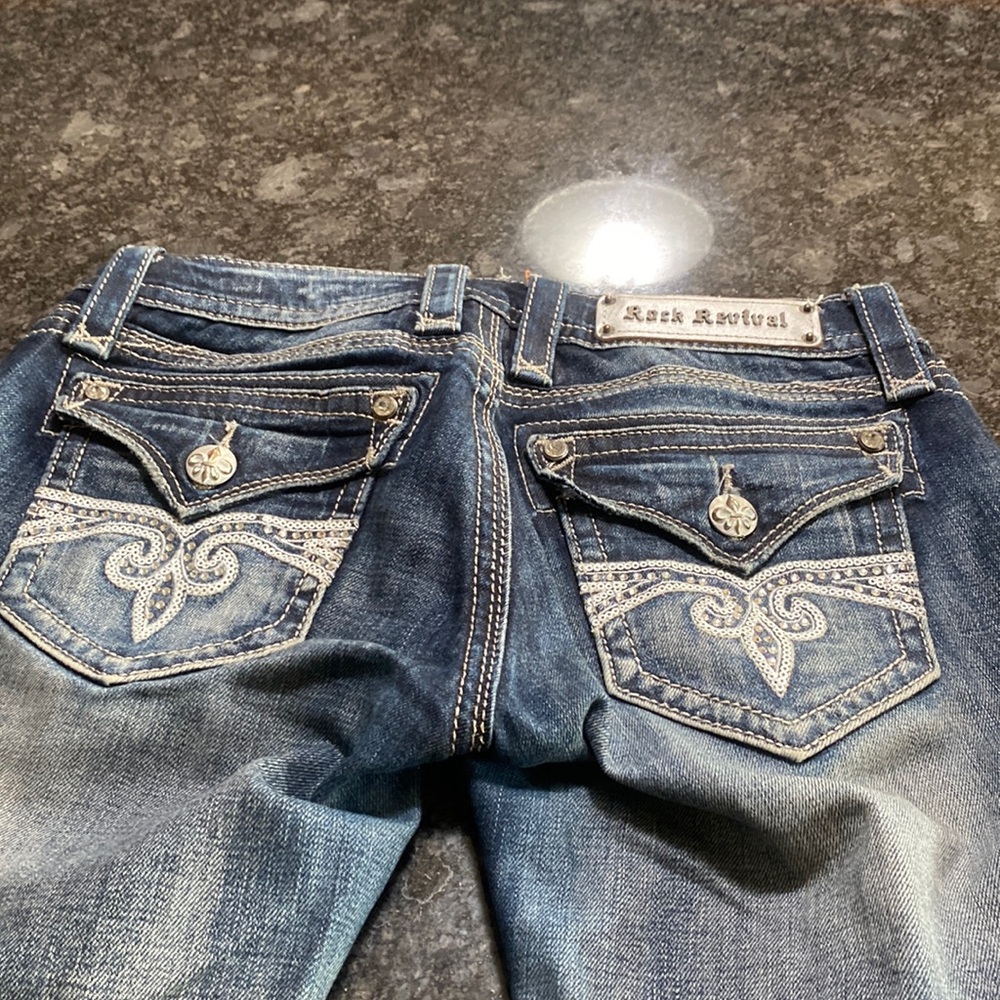 Slightly worn boot cut leg low waisted embellished Rock revival jeans. Sz 27
